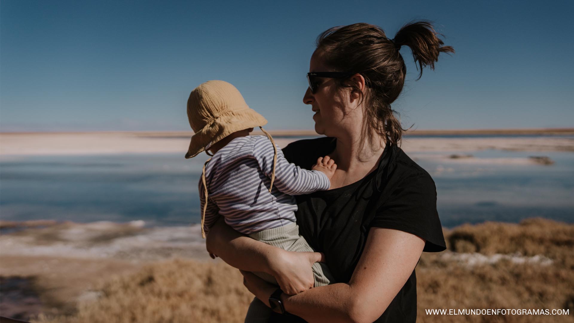 Retrato de madre e hijo posando en una laguna del desierto de Atacama